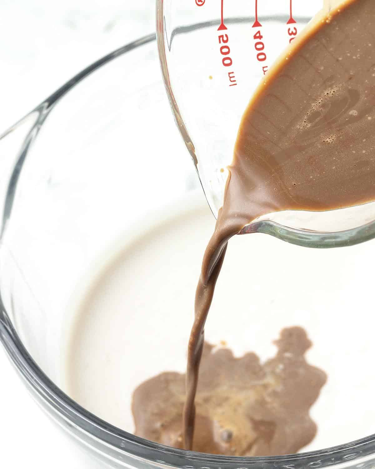 Coffee mixture being poured into the other base ingredients to make coffee ice cream.
