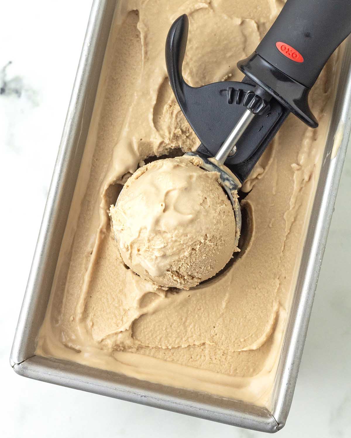 An ice cream scoop filled with coffee ice cream.